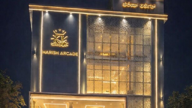 A modern building with a prominent sign for "Harish Arcade" and "Cafe Bhadrachalam" at the ground level. - Bhadrachalam Nest Inn (Mysore)