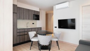 Una cocina moderna con microondas, un lavamanos y un comedor con una mesa redonda y dos sillas.