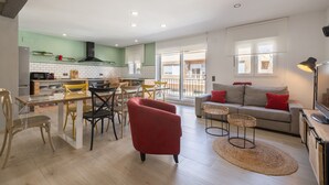 A spacious living area with a dining table, red armchair, and a sofa with red cushions. - Apartment in Deltebre Casa Fotostudi37 (Deltebre)