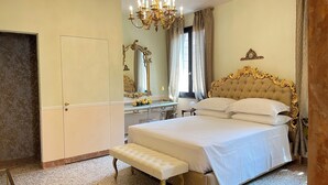 Una camera da letto con un letto grande, una toeletta con specchio e un lampadario.