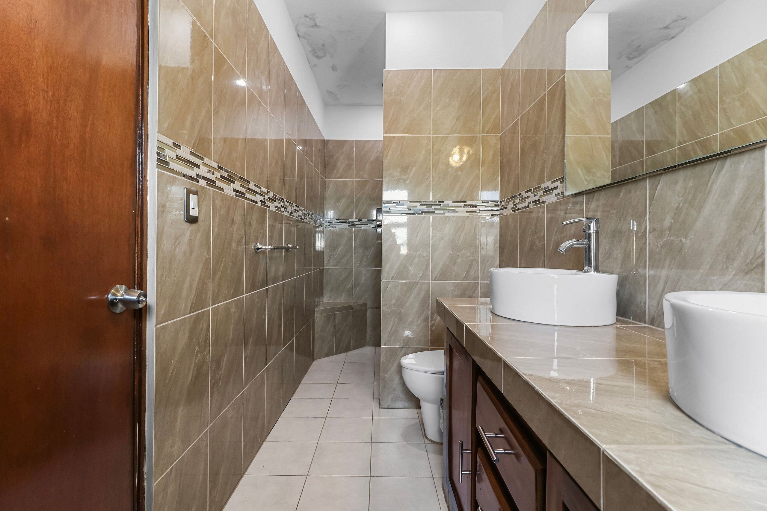 Un bagno moderno con un vanità in marmo, un WC e uno spazio doccia.