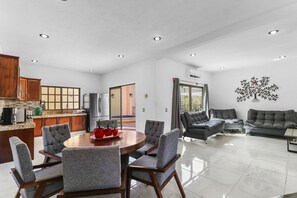A modern living space with a dining area, kitchen, and seating area. - Luxury 4BR Villa with Pool  (Puerto Vallarta)