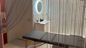 Ein modernes Badezimmer mit Duschkabine aus Glas, einer Sitzbank und einem Waschtisch mit Spiegel.