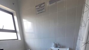 Une petite salle de bain avec des toilettes, un lavabo et des carreaux de sol à motifs.