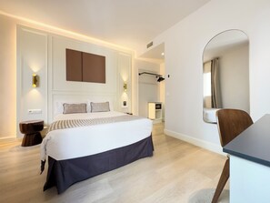 Ein modernes Schlafzimmer mit einem großen Bett, Nachttischen, einem Spiegel und einem Schreibtisch.