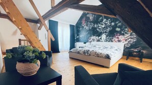 A bedroom with a bed, a desk, a chair, and a potted plant. - Former wine château (Winningen)