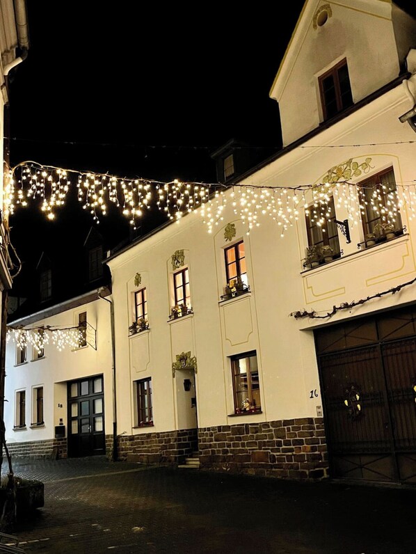 A building with a white facade, multiple windows, and a brick base. - Former wine château (Winningen)