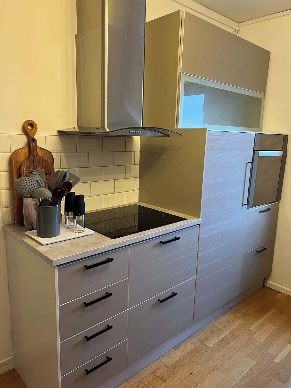 Uma cozinha moderna com fogão embutido, armários de aço inoxidável e micro-ondas.