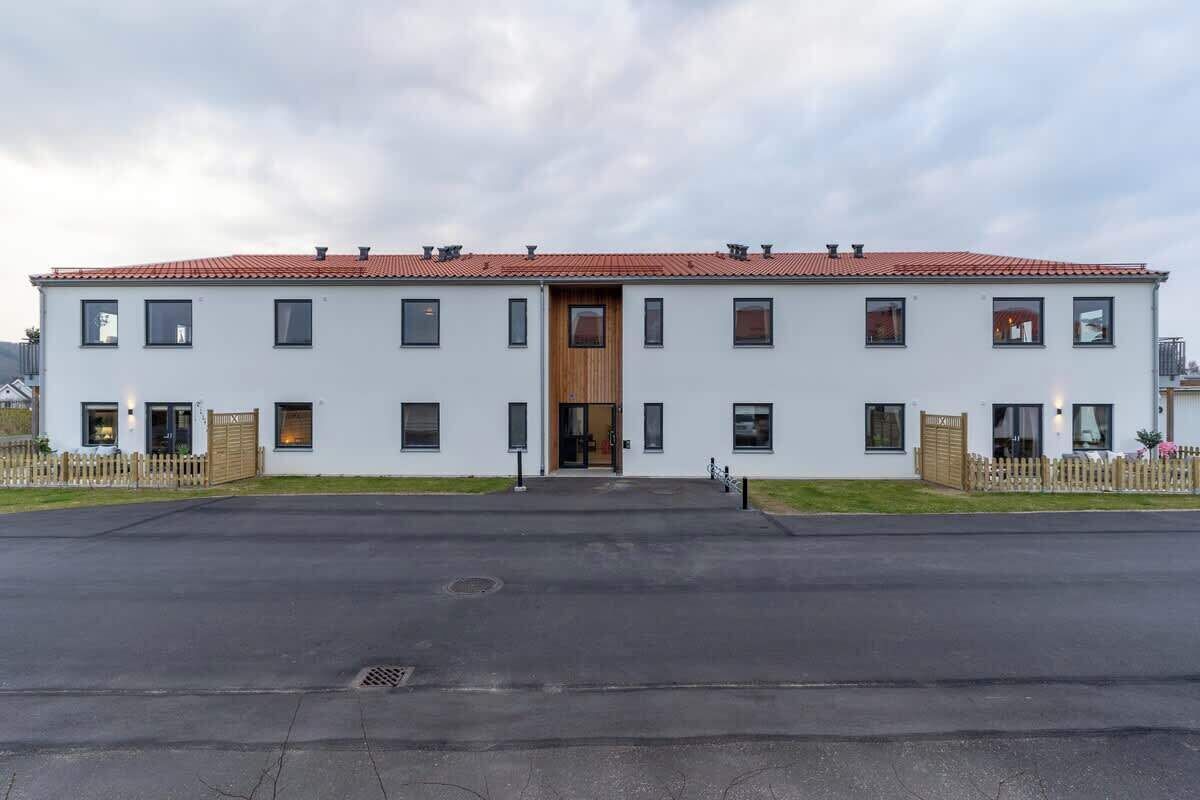 Un bâtiment à deux étages, doté d’un toit recouvert de tuiles rouges, de nombreuses fenêtres et d’une porte centrale en bois.