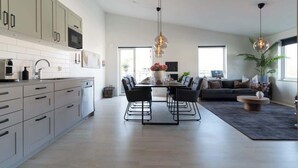 Una cocina moderna con armarios grises, un microondas y un comedor con mesa y sillas.