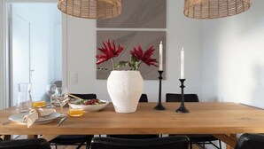 A dining table set with plates, glasses, and a bowl of salad. - Spacious Home with Workspace and Cozy Balcony (Båstad)