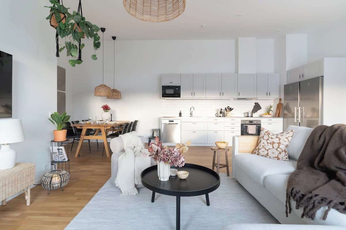 Un salon moderne comprenant un canapé, une table basse et un coin repas avec une table et des chaises.
