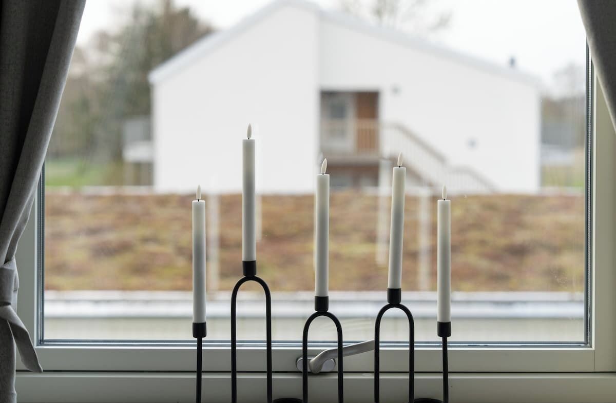 A window with a candle holder containing five candles.