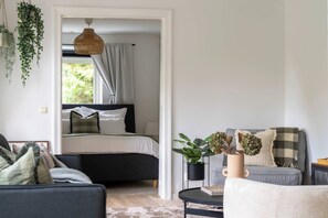 A modern bedroom with a bed, bedside table, and a hanging plant. - Fully Equipped Cosy Flat Close to Malmo Copenhagen (Vellinge)