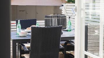 Een terras met een tafel, stoelen en een fles Pellegrino water.