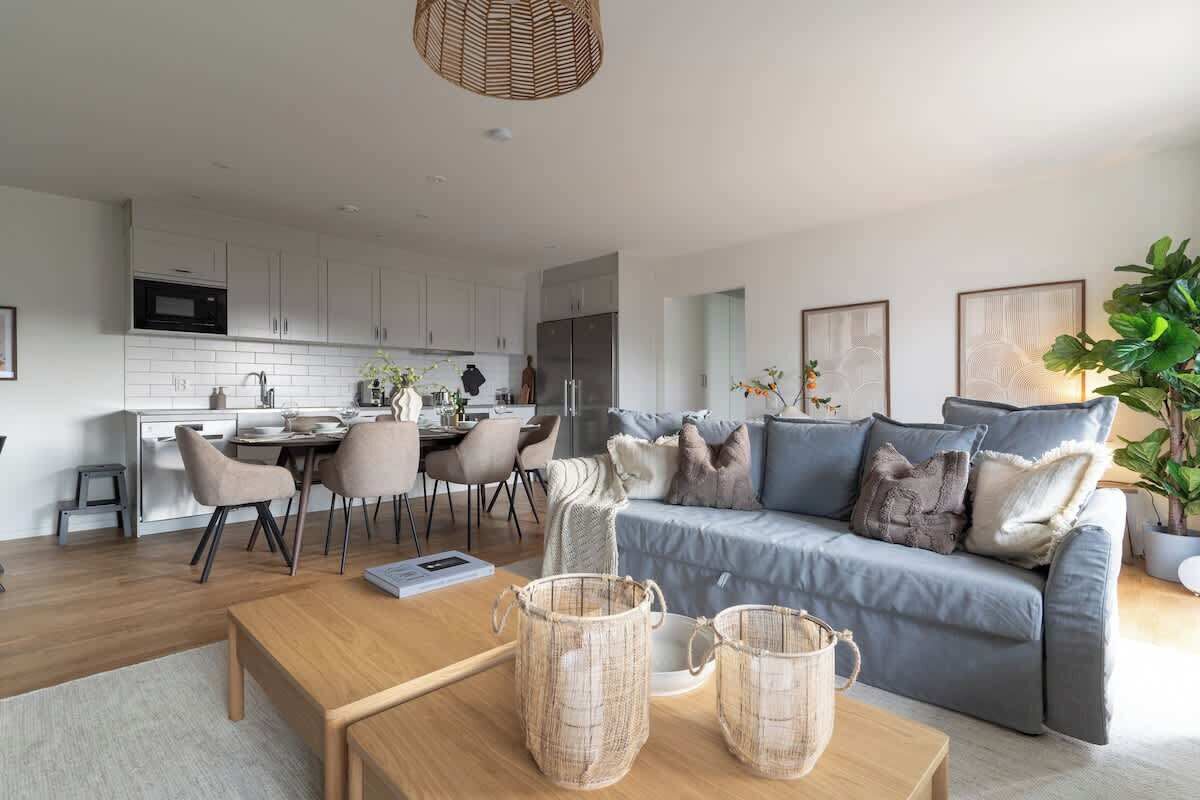 A modern living room with a sofa, coffee table, and dining area.