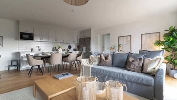 A modern living room with a sofa, coffee table, and dining area.