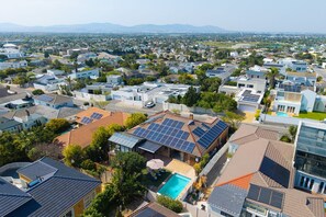 Een woonwijk met huizen, zonnepanelen en een zwembad.