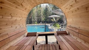 A wooden cabin with a pool and outdoor seating.