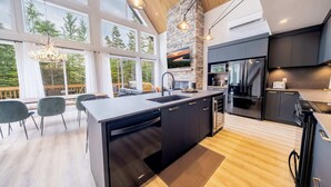 A modern kitchen with a large island, built-in appliances, and a stone accent wall.