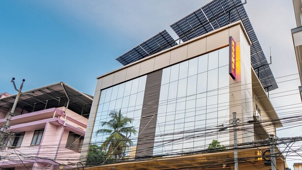 Un bâtiment doté de panneaux solaires sur le toit, une enseigne indiquant « Résidence pour bateaux, avec ou sans climatisation », et une devanture de magasin avec une enseigne au néon.