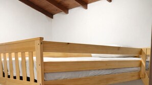 A bunk bed with a wooden frame and white bedding.