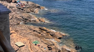 In StrandnĂ€he, schwarzer Sandstrand, LiegestĂŒhle