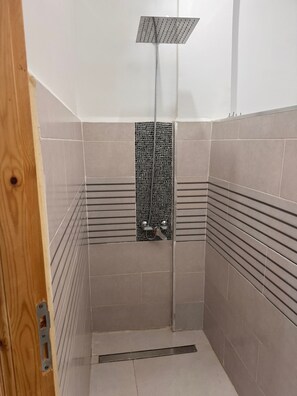Een douche, handdoeken, toiletpapier