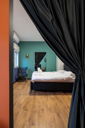 Une chambre à coucher comprenant un lit, une chaise, une fenêtre et un appareil de climatisation.