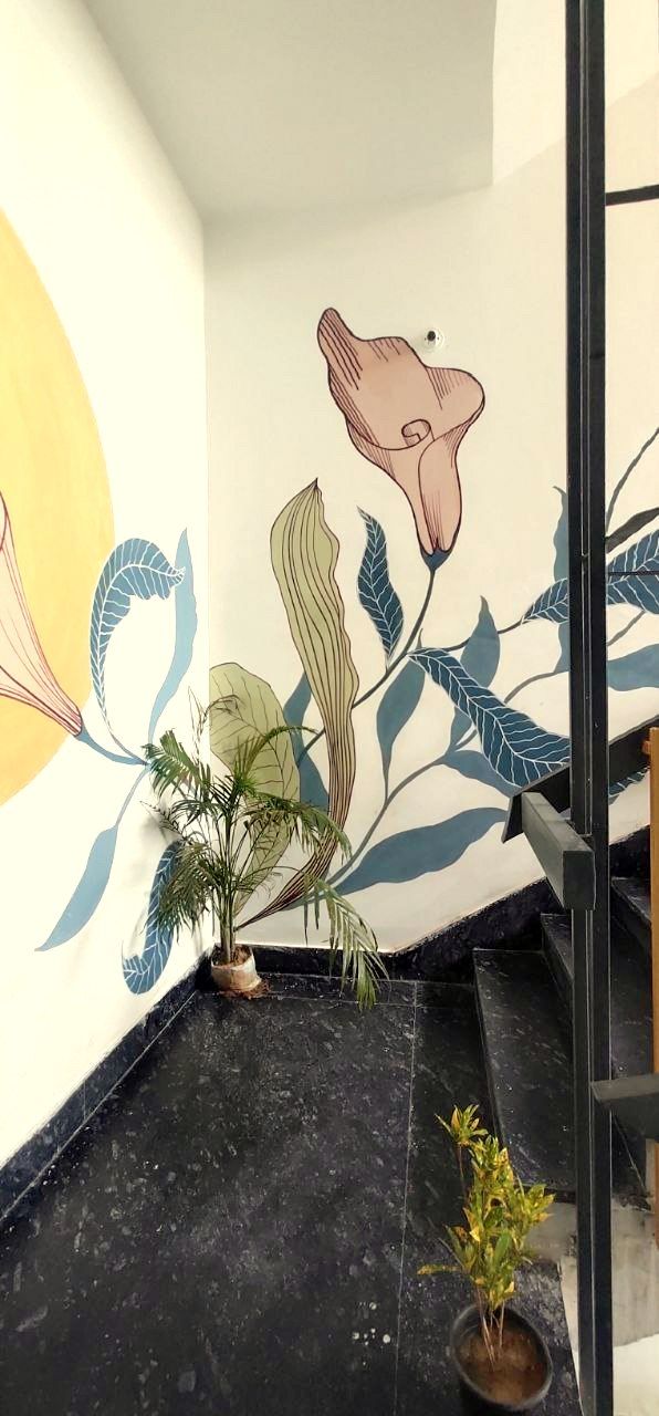A staircase with a wall mural featuring stylized plant illustrations.