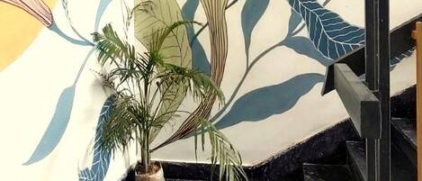 A staircase with a wall mural featuring stylized plant illustrations.