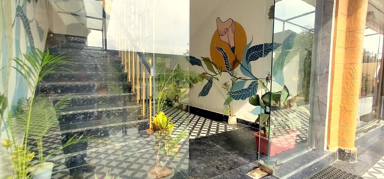 A staircase with a checkered floor pattern leading to a room with a glass wall and a mural.