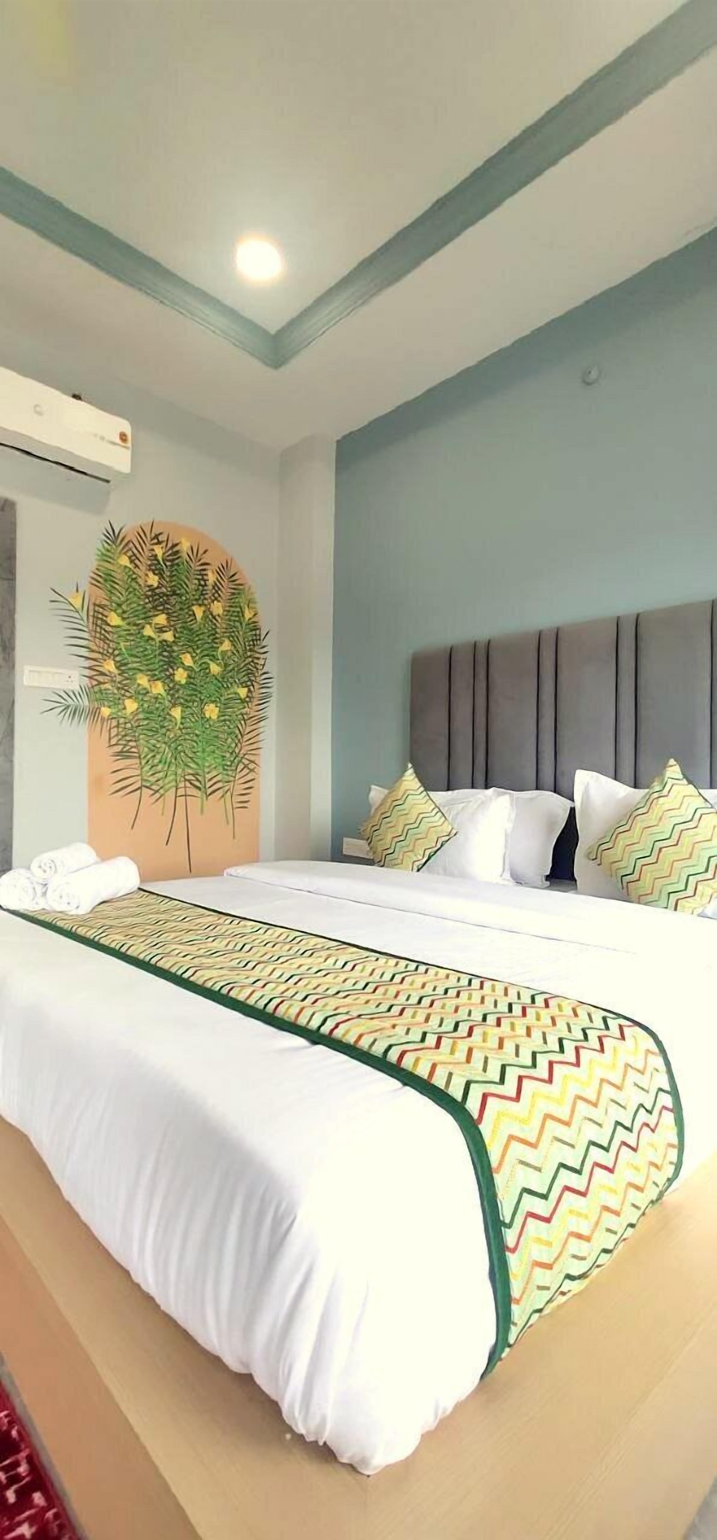 A hotel room with a bed, a headboard, and a wall decoration.