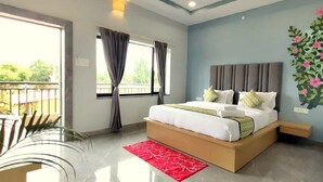 Un dormitorio moderno con cama, ventana con cortinas, balcón y un mural floral en la pared.