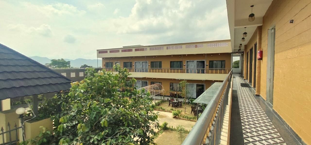 A multi-story building with a balcony overlooking a courtyard.