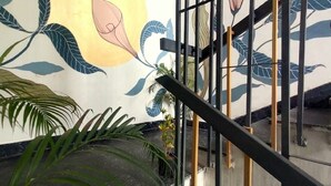 Una escalera con barandilla y una pared con diseño de hojas.