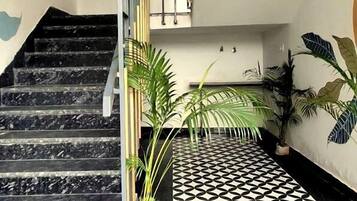 A staircase with black marble steps, a metal railing, and a patterned floor.