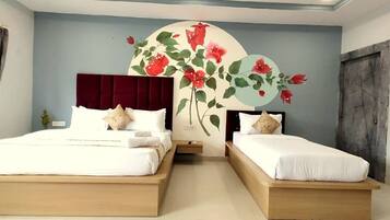 Un dormitorio con dos camas, un amplio mural floral en la pared y una puerta de madera oscura.