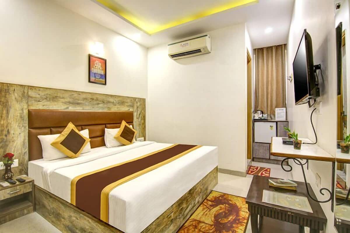 Une chambre d’hôtel équipée d’un grand lit, d’un bureau, d’une télévision et d’un appareil de climatisation.