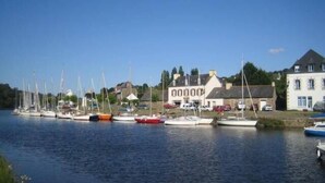 A marina with several boats docked, a white building with a sign, and a clear blue sky. - Charming cottage in the countryside (6 bedrooms) (Saint-Clet)