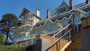 Ein mehrstöckiges Gebäude mit einer Holztreppe, die zu einem Balkon führt.