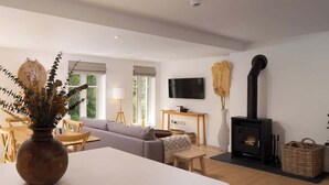 Ein modernes Wohnzimmer mit einer Couch, einem Couchtisch, einem Kamin und einem an der Wand montierten Fernseher.