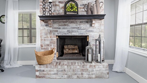 Una chimenea de ladrillo, una cesta y objetos decorativos.