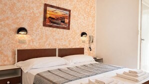 Ein Hotelzimmer mit einem Bett, zwei Nachttischen, einem Gemälde an der Wand und einem Telefon.