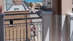 Ein Balkon mit Blick auf Strand und Gebäude.