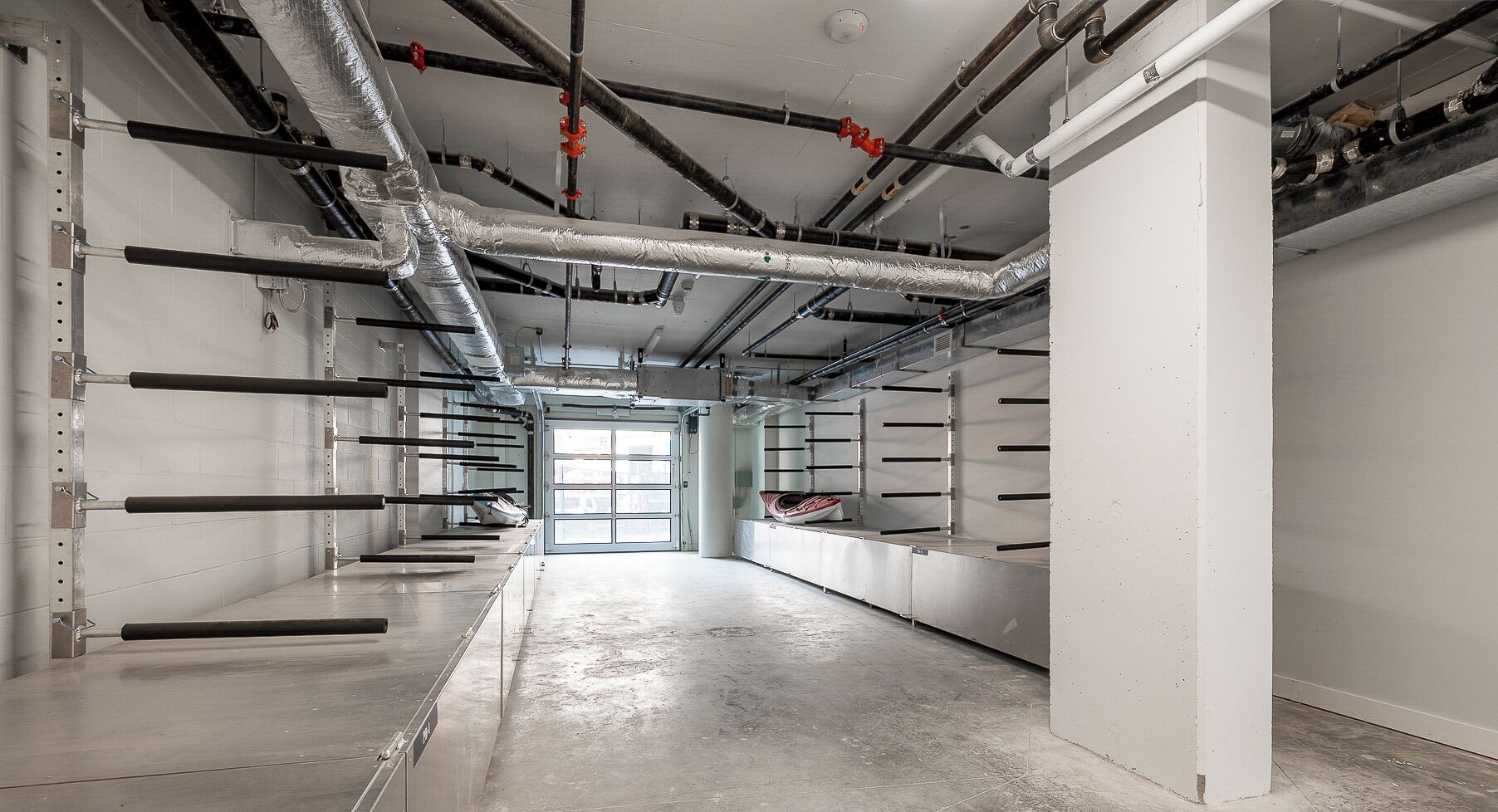A clean, industrial-style room with exposed ductwork, metal beams, and a concrete floor.