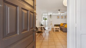 A modern interior with a dining area, a sofa, and a lamp.