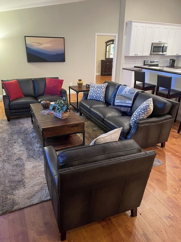 A living room with a sectional sofa, a coffee table, and a fireplace.