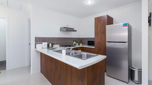 Una cocina moderna con una isla central, electrodomésticos de acero inoxidable y un microondas.