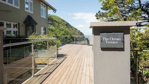 A wooden deck leading to a building with a sign reading "The Ocean Terrace".
